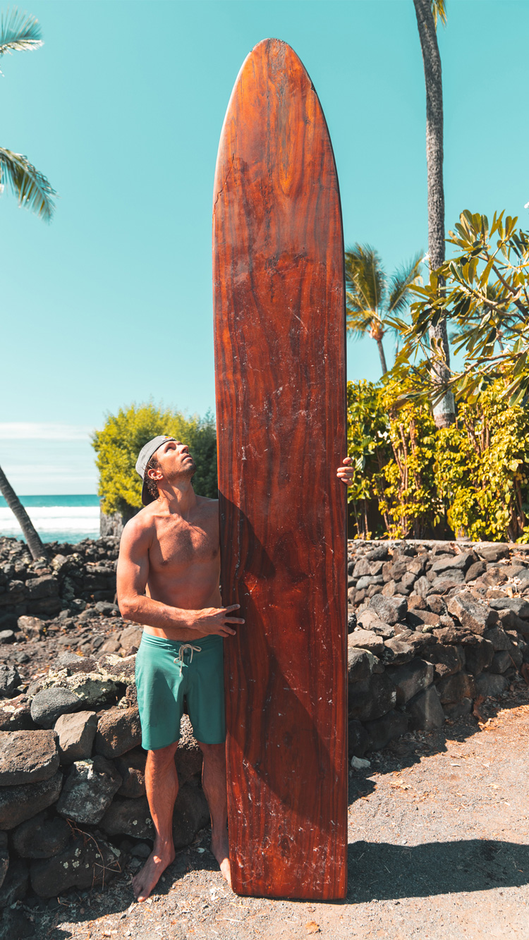 Hawaii: Hugo Pinheiro stands next to an ancient wooden surfboard | Photo: Red Bull