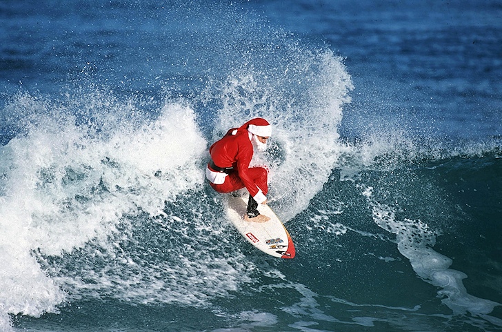 Surfing Santa Claus: coming to town with bag full of gifts