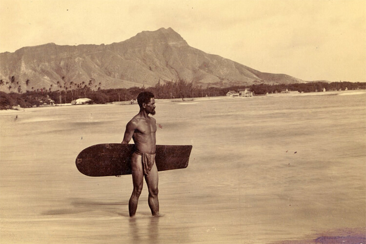 Charles Kauha, 1898: the Hawaiian surfer wearing the malo at Waikiki Beach carries one of the last alaia surfboards | Photo: Frank Davey