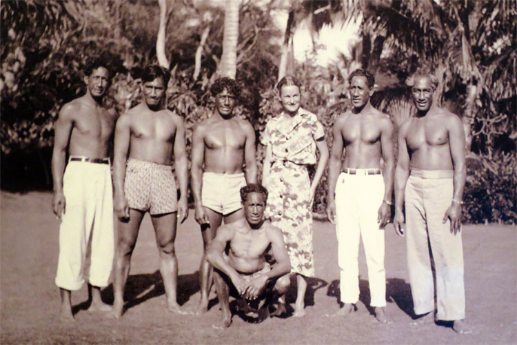 Doris Duke and the Kahanamoku brothers, circa 1937: the Hawaiian surf crew featuring Sargent Kahanamoku, Louis Kahanamoku, Sam Kahanamoku, Bill Kahanamoku (seated), Doris Duke, David Kahanamoku, and Duke Kahanamoku (left to right) | Photo: Creative Common